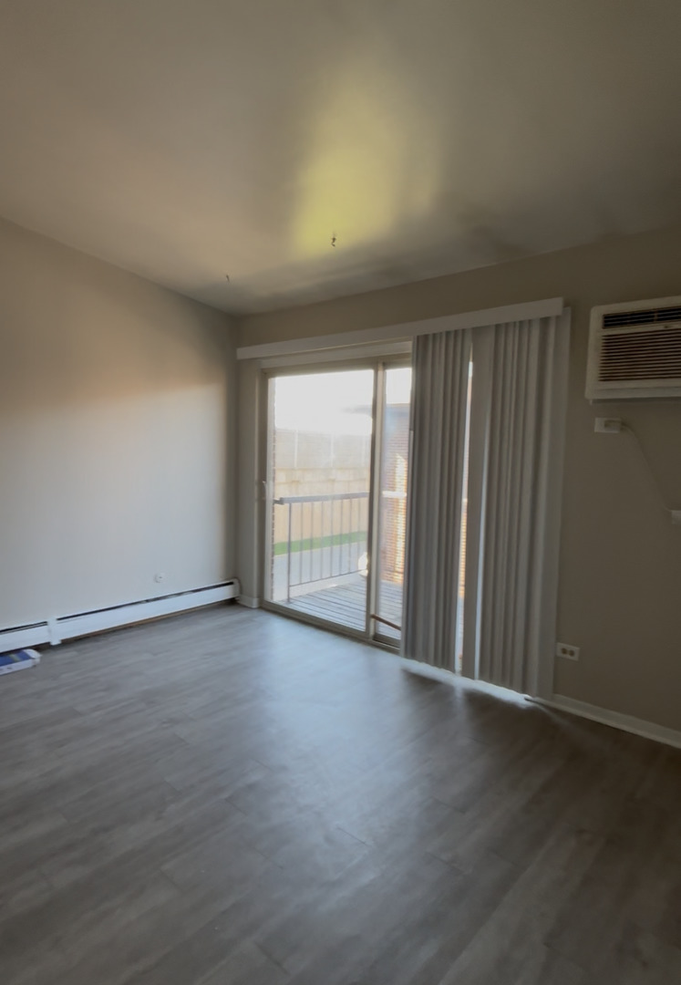 3068 Bernice Avenue, Unit 3S Lansing, IL 60438 - Photo 2 of 8 wooden floor in an empty room with a window