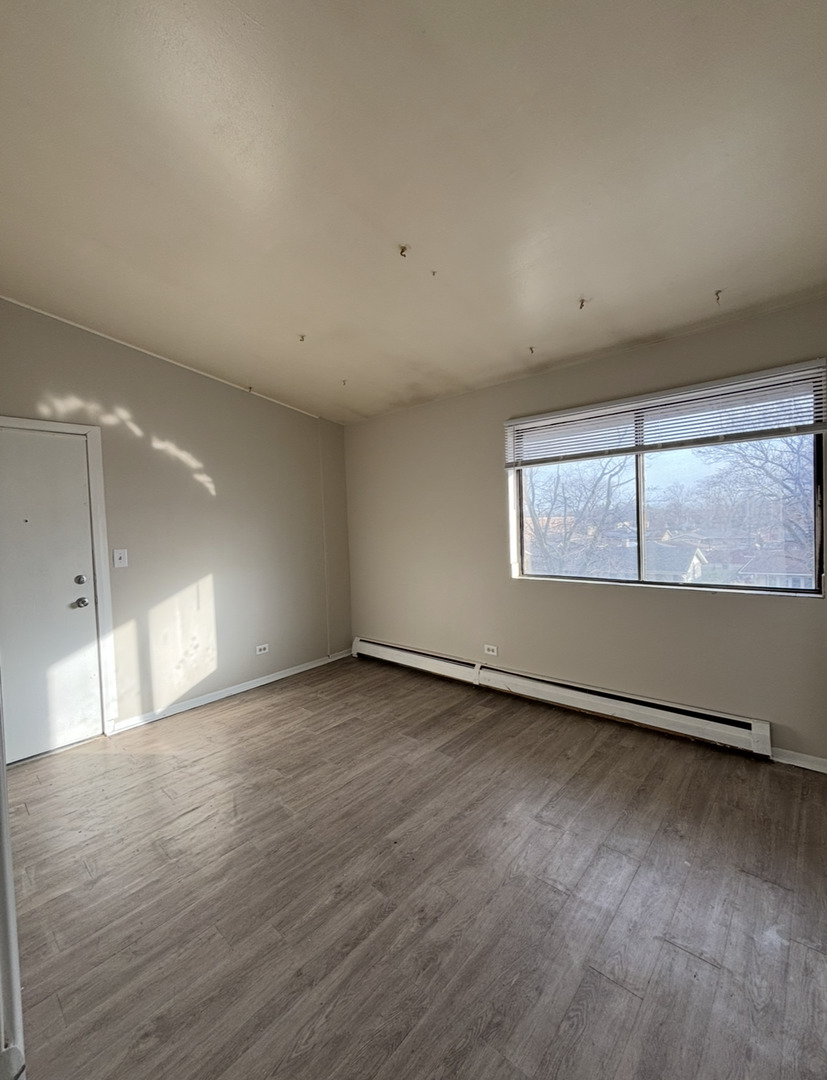 3068 Bernice Avenue, Unit 3S Lansing, IL 60438 - Photo 5 of 8 an empty room with wooden floor and windows