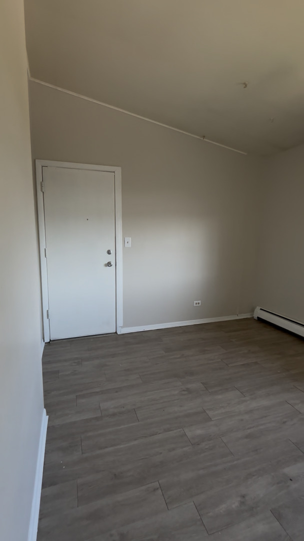 3068 Bernice Avenue, Unit 3S Lansing, IL 60438 - Photo 5 of 8 a view of a room with an empty space and wooden floor