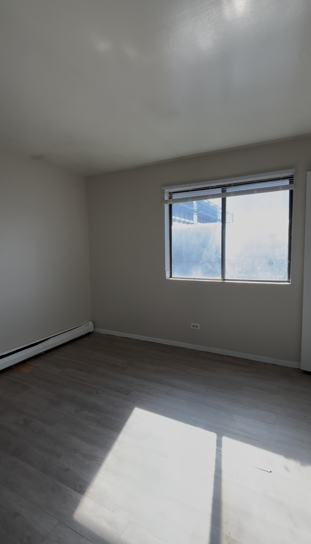 3068 Bernice Avenue, Unit 3S Lansing, IL 60438 - Photo 6 of 8 an empty room with wooden floor and windows