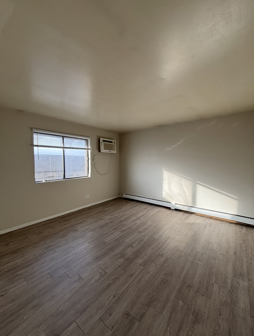 3068 Bernice Avenue, Unit 3S Lansing, IL 60438 - Photo 7 of 8 a view of an empty room with wooden floor and a window