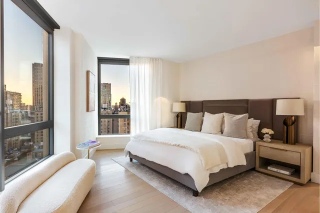 a bedroom with a bed lamp and a large window