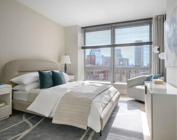 a bedroom with a bed and a large window