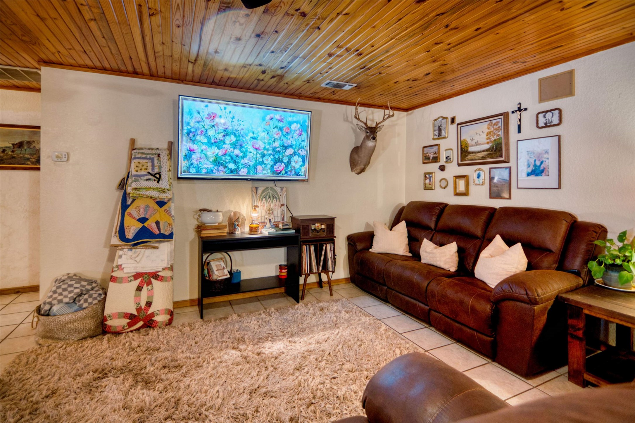 904 Bluebonnet Road Mason, TX 76856 - Photo 10 of 28 Living area featuring a wood-panel ceiling, light-toned walls, and tile flooring