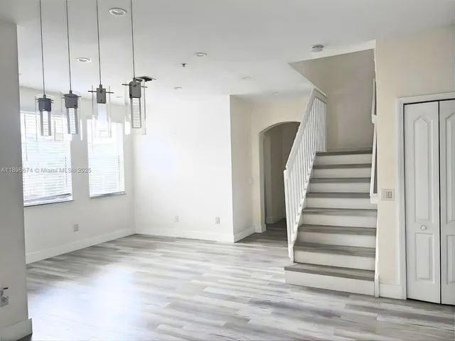 a view of a room with wooden floor and entryway