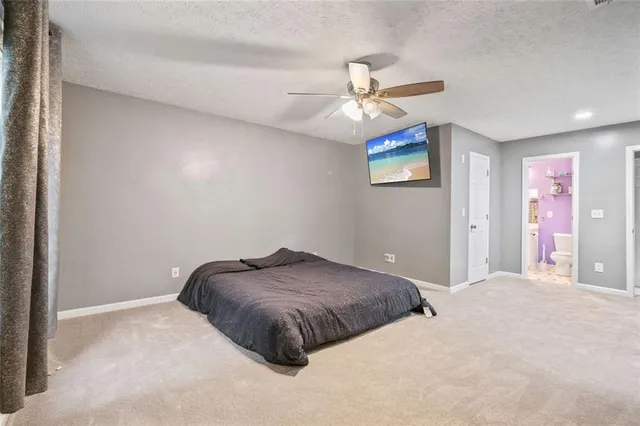 a bedroom with a bed and a ceiling fan