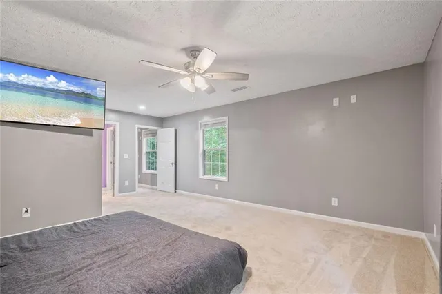 a view of a big room with windows and chandelier fan