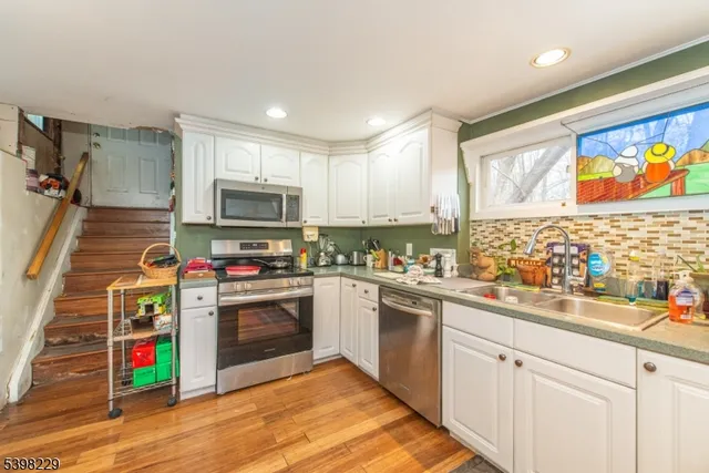 a kitchen with kitchen island granite countertop wooden cabinets stainless steel appliances and a sink