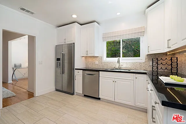 a kitchen with stainless steel appliances granite countertop a refrigerator and a sink
