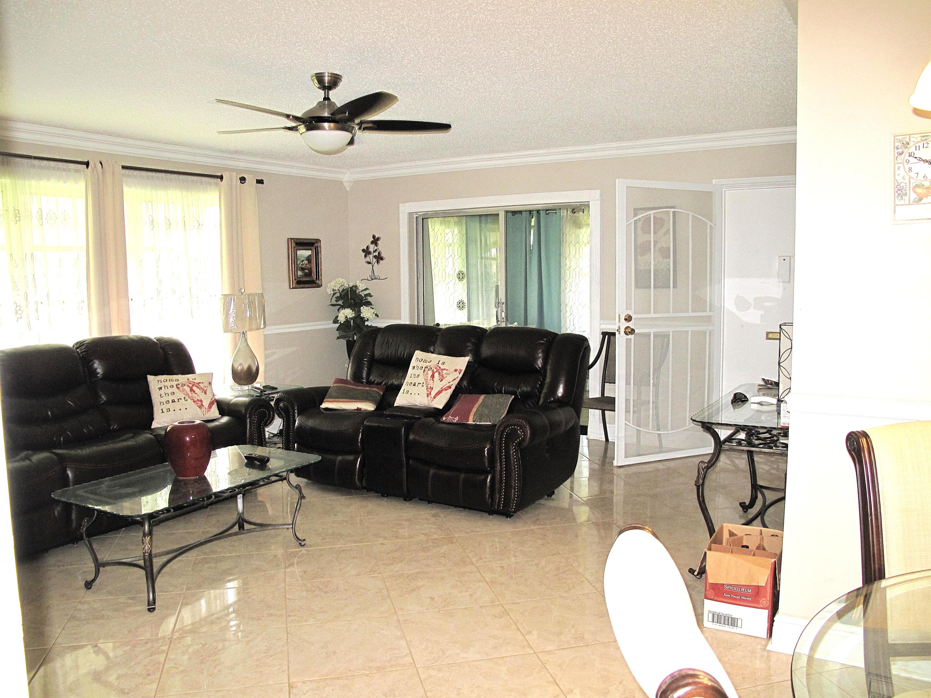 892 North High Point Boulevard North, Unit D Delray Beach, FL 33445 - Photo 18 of 44 a living room with furniture ceiling fan and a window