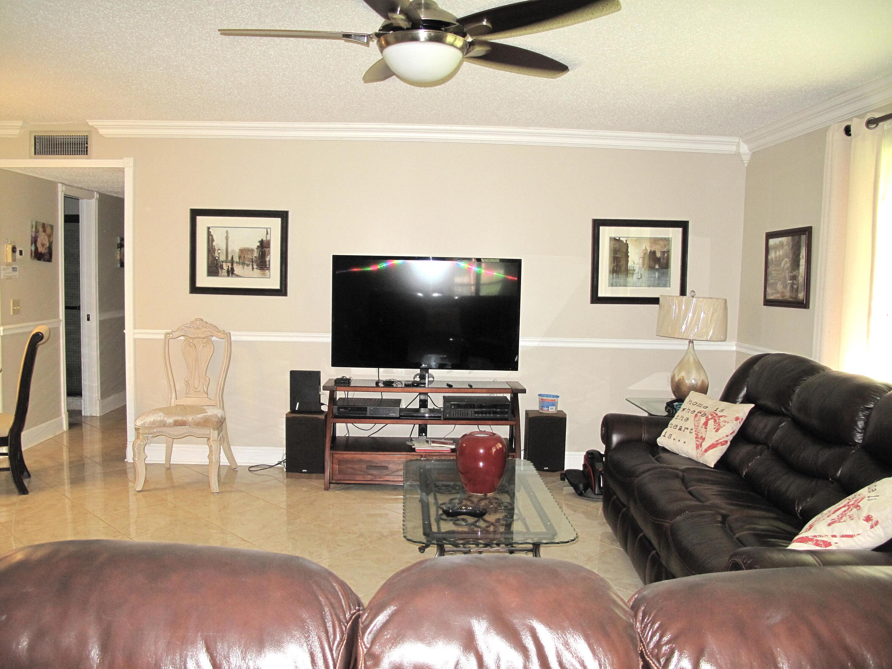 892 North High Point Boulevard North, Unit D Delray Beach, FL 33445 - Photo 19 of 44 a living room with furniture and a flat screen tv