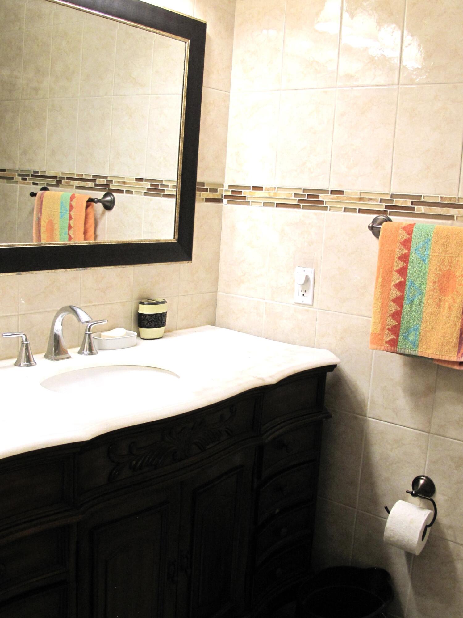 892 North High Point Boulevard North, Unit D Delray Beach, FL 33445 - Photo 22 of 44 a bathroom with a sink and a mirror
