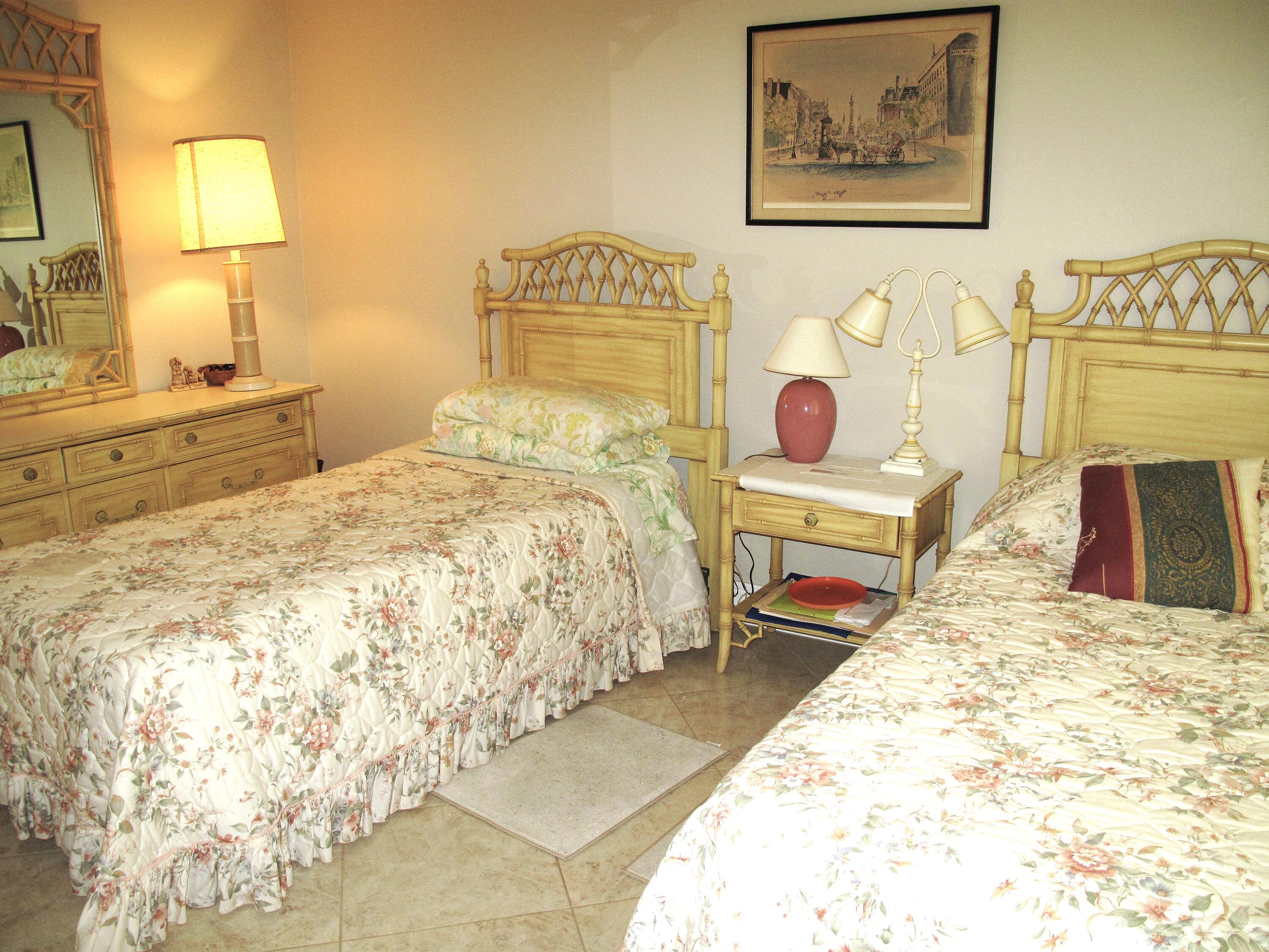 892 North High Point Boulevard North, Unit D Delray Beach, FL 33445 - Photo 23 of 44 a bedroom with a bed and a lamp on table