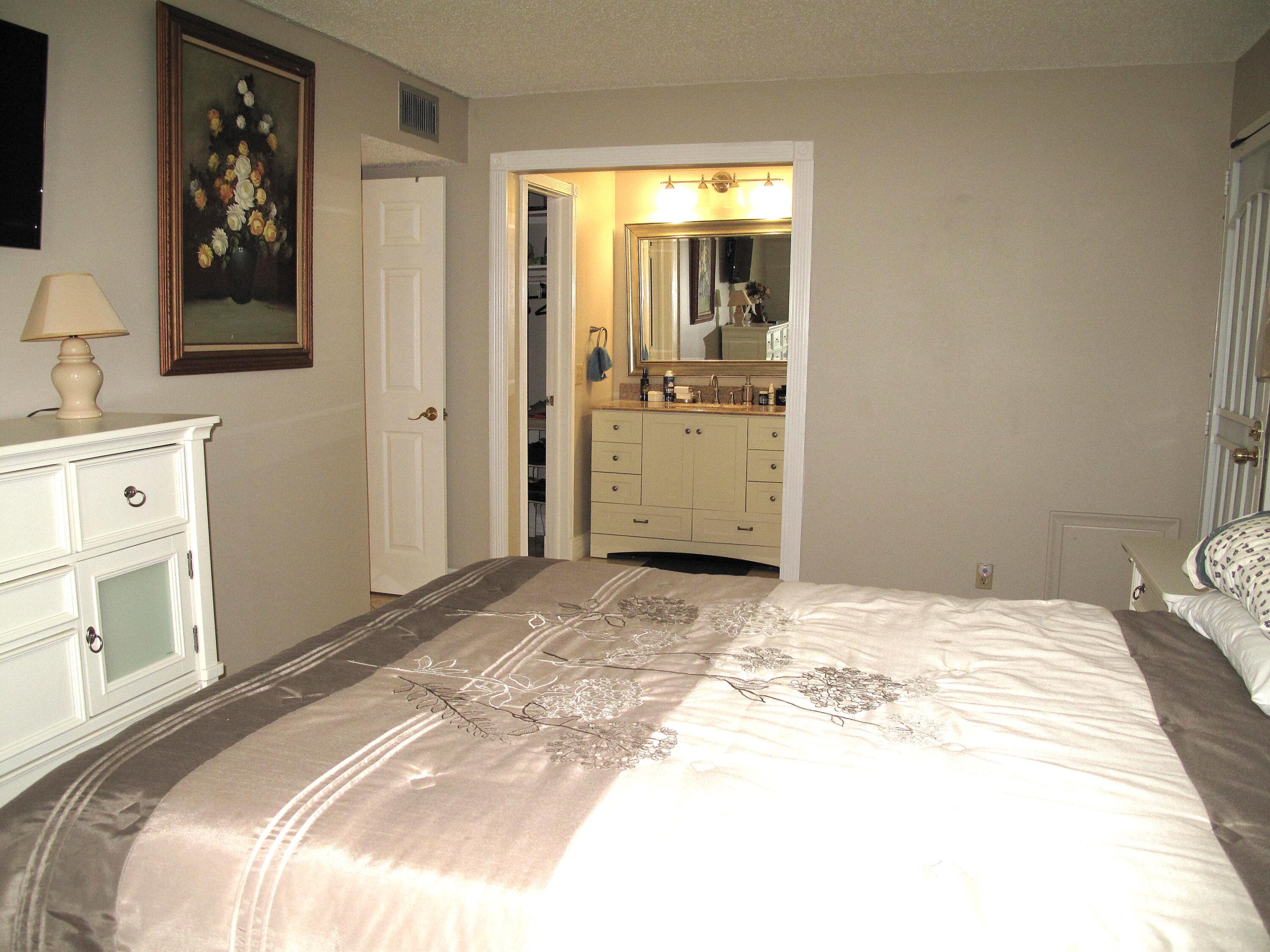 892 North High Point Boulevard North, Unit D Delray Beach, FL 33445 - Photo 28 of 44 a bedroom with a bed and a view of bathroom