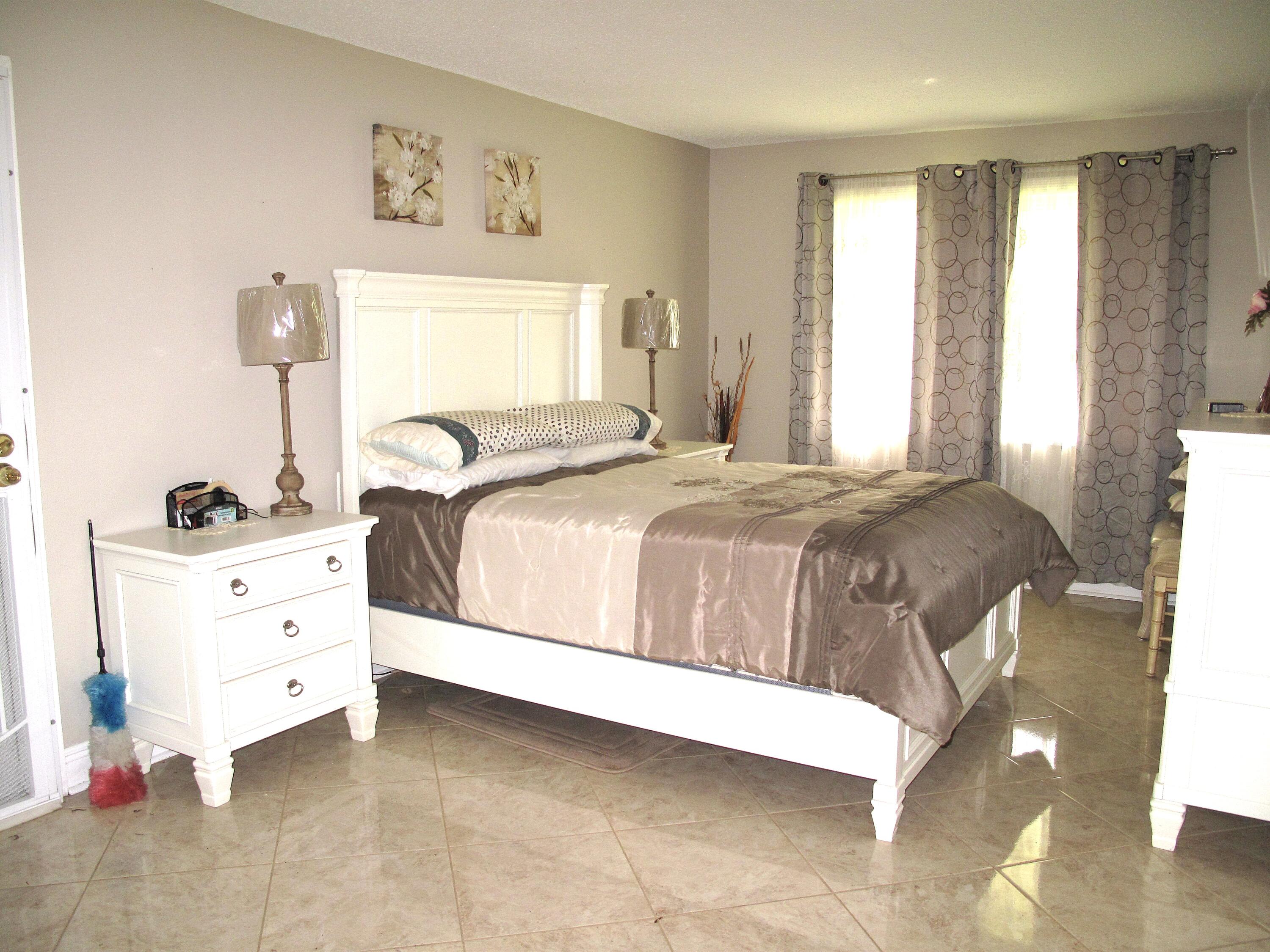 892 North High Point Boulevard North, Unit D Delray Beach, FL 33445 - Photo 29 of 44 a bedroom with a bed and a window