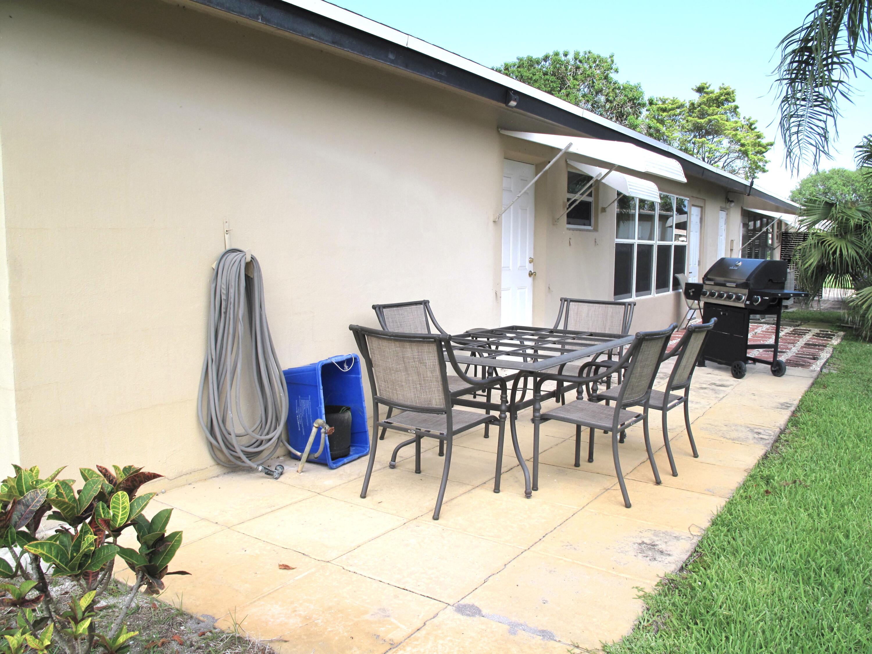 892 North High Point Boulevard North, Unit D Delray Beach, FL 33445 - Photo 31 of 44 a view of a patio with table and chairs and potted plants