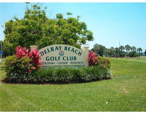 892 North High Point Boulevard North, Unit D Delray Beach, FL 33445 - Photo 36 of 44 a sign of golf club on a wall under a tree