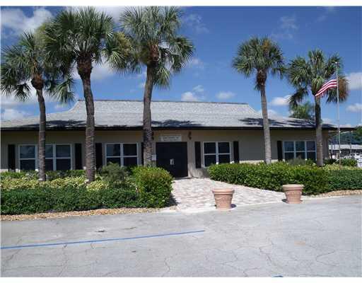 892 North High Point Boulevard North, Unit D Delray Beach, FL 33445 - Photo 37 of 44 a front view of a house with a garden and palm trees