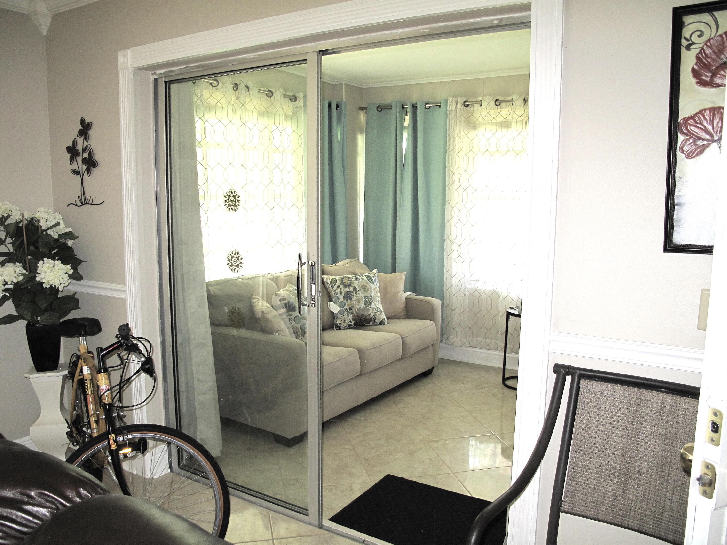 892 North High Point Boulevard North, Unit D Delray Beach, FL 33445 - Photo 4 of 44 a living room with furniture and a large window