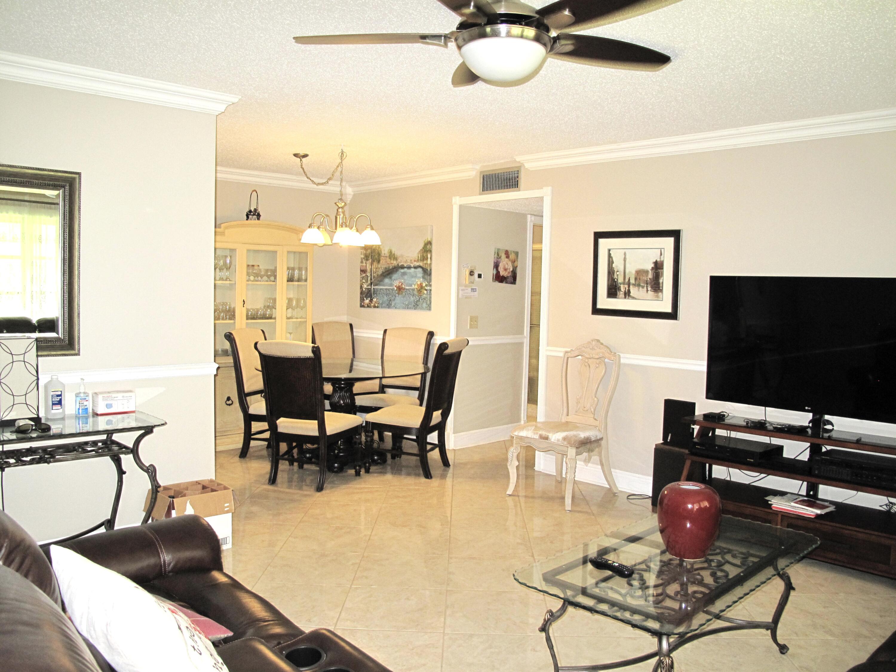 892 North High Point Boulevard North, Unit D Delray Beach, FL 33445 - Photo 5 of 44 a living room with furniture and a flat screen tv