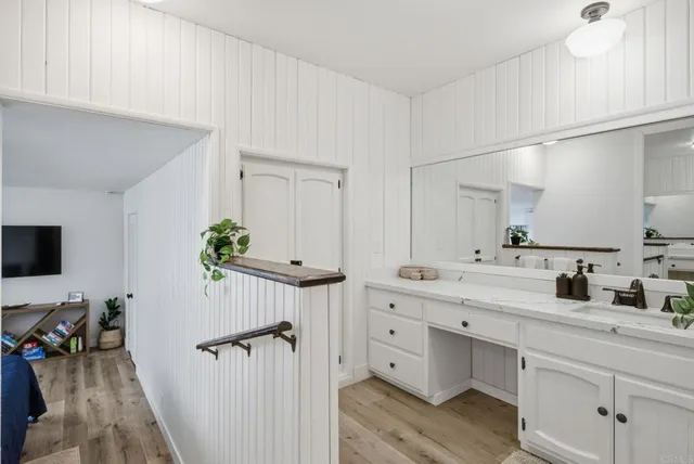 a bathroom with a granite countertop sink a mirror and shower