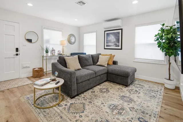 a living room with furniture a flat screen tv and a potted plant