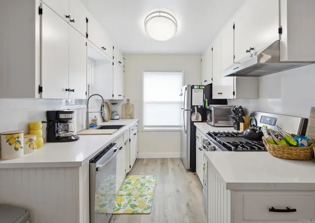 a kitchen with a sink a refrigerator and cabinets
