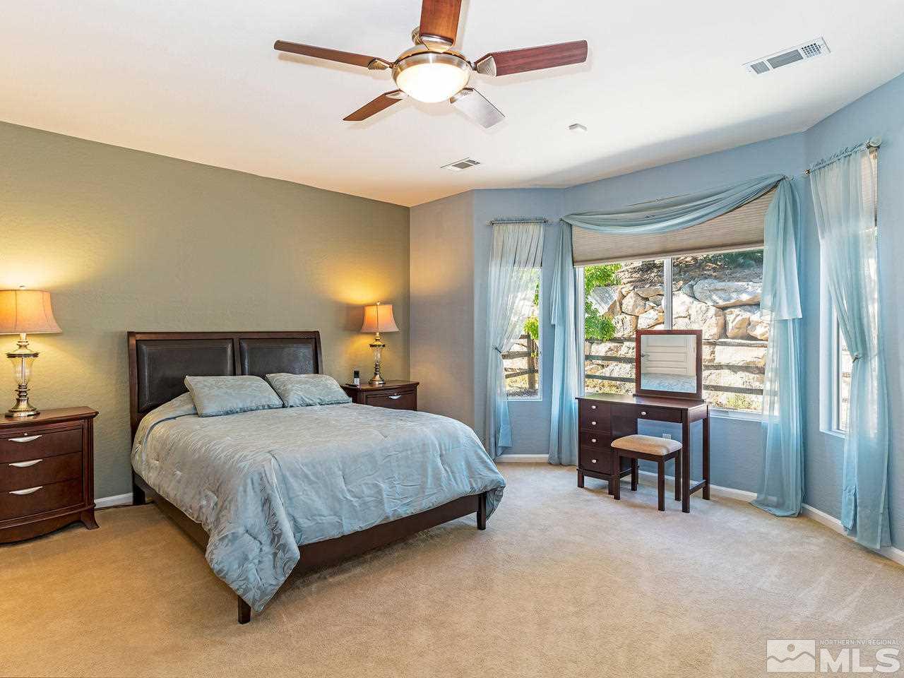 9149 Quilberry Way Reno, NV 89523 - Photo 14 of 20 a bedroom with a bed and a chandelier