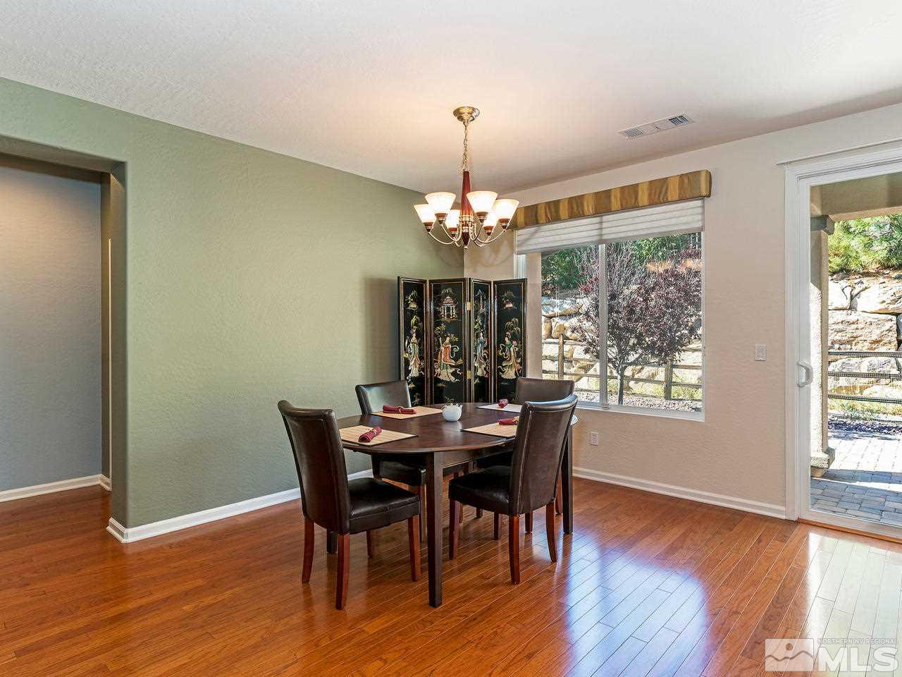 9149 Quilberry Way Reno, NV 89523 - Photo 7 of 20 a dining room with wooden floor a chandelier a wooden table and chairs