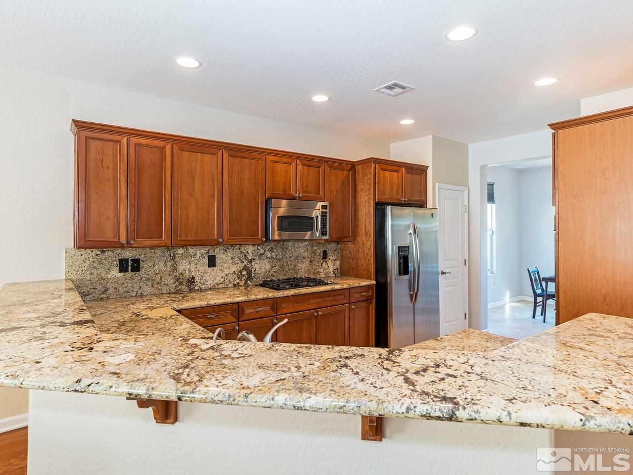 9149 Quilberry Way Reno, NV 89523 - Photo 8 of 20 a large kitchen with kitchen island granite countertop a sink and refrigerator