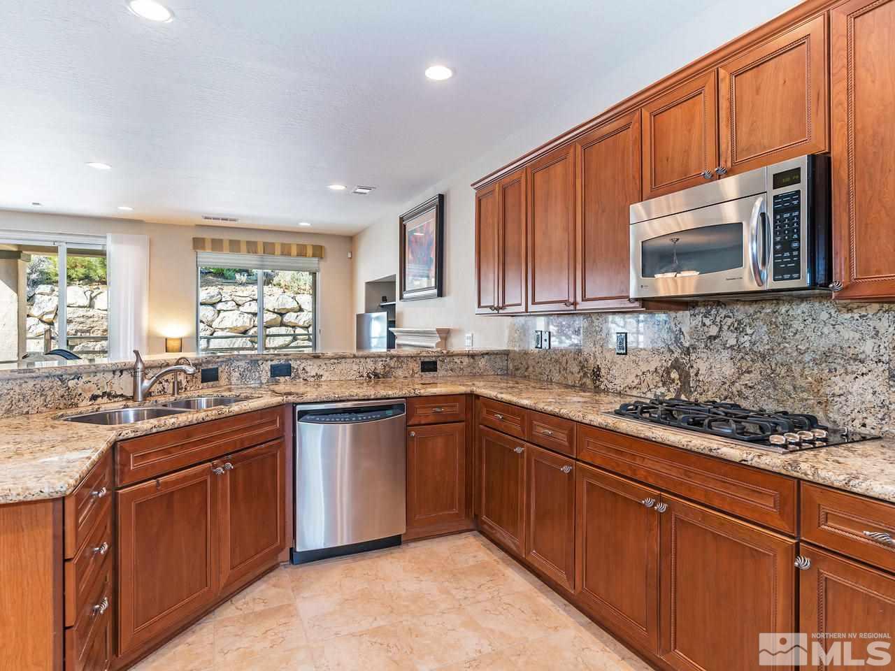 9149 Quilberry Way Reno, NV 89523 - Photo 9 of 20 a kitchen with stainless steel appliances granite countertop wooden cabinets a sink and dishwasher a stove top oven with wooden floor