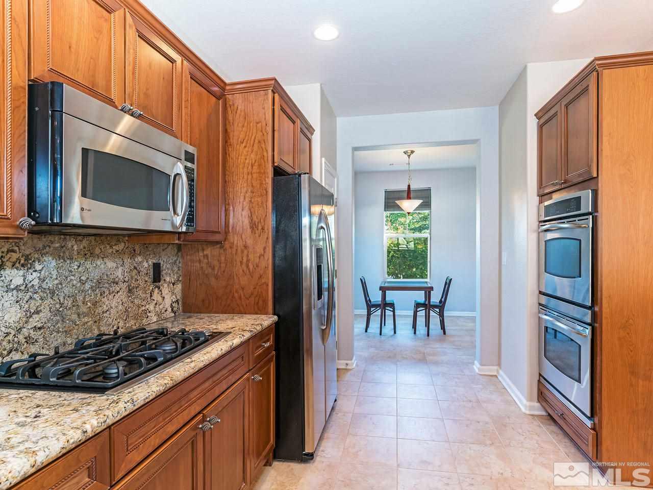 9149 Quilberry Way Reno, NV 89523 - Photo 10 of 20 a kitchen with stainless steel appliances granite countertop a stove a microwave and a refrigerator
