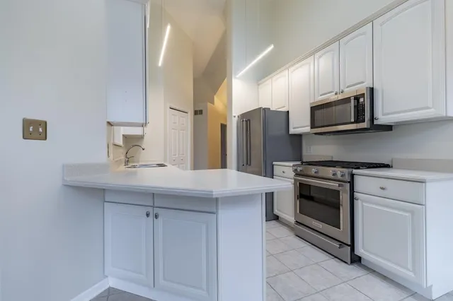 a kitchen with stainless steel appliances a stove microwave and refrigerator