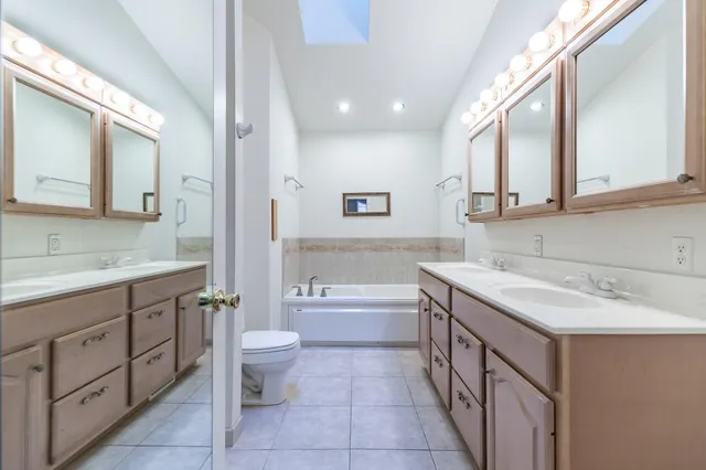 a bathroom with a granite countertop sink a toilet and a bathtub