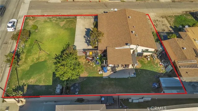 a view of a small house with a small yard and a large tree