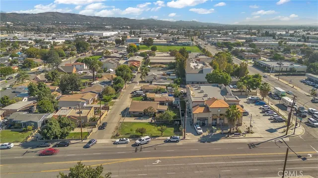 a view of a small house with a small yard and a large tree