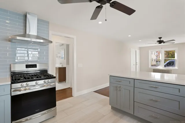 a kitchen with stainless steel appliances a stove and a white cabinets