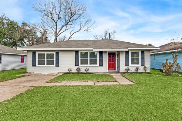 a front view of a house with a yard and trees