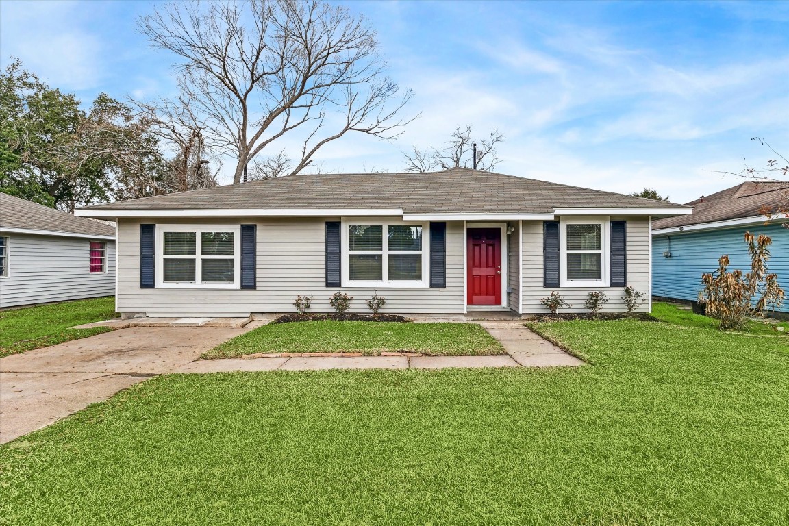 a front view of a house with a yard and trees