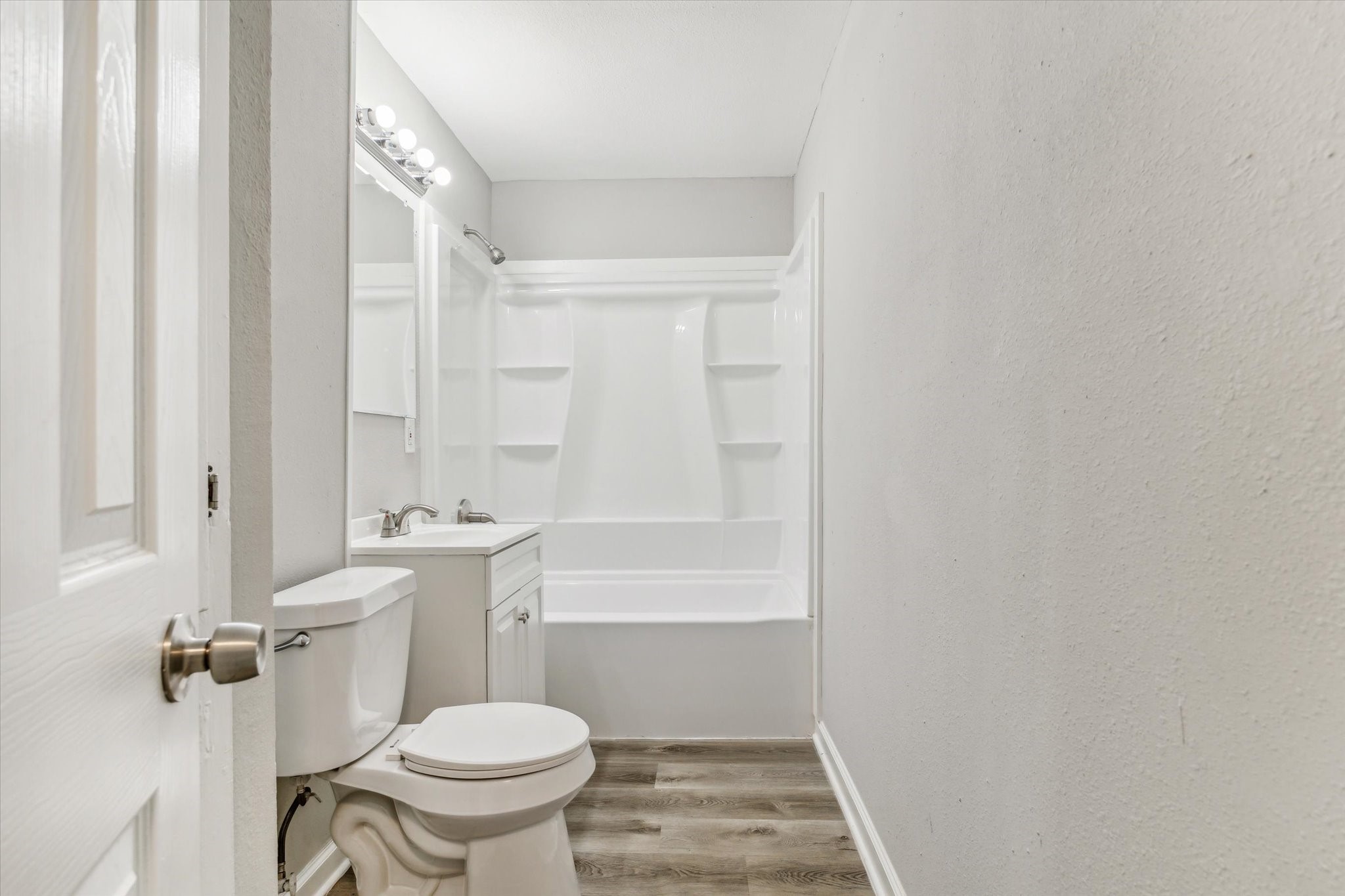 5130 Ripplebrook Drive Houston, TX 77045 - Photo 14 of 19 Guest bathroom has new vanity with vanity lights, new toilet and new tub/shower combination.