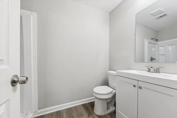 a bathroom with a toilet a sink a mirror and vanity