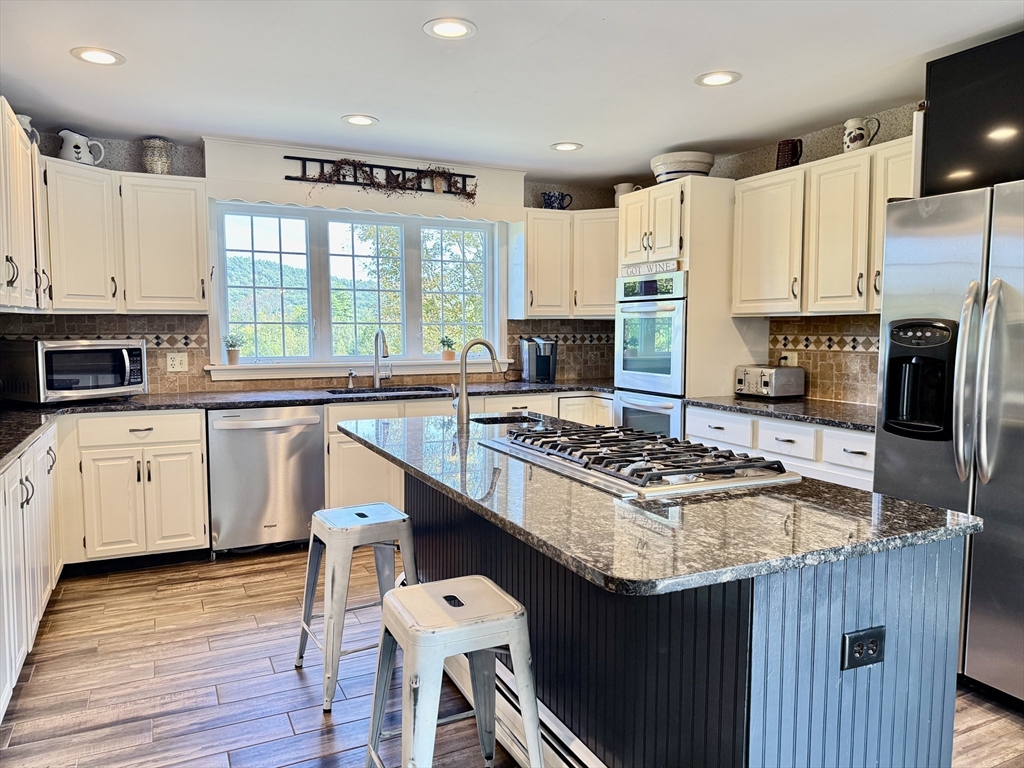 41 Hog Hollow Road Buckland, MA 01370 - Photo 4 of 42 a kitchen with a stove a sink wooden floor and a window
