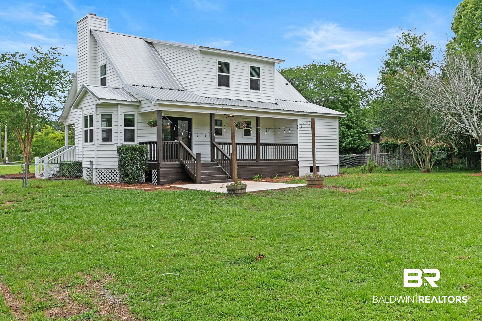 22810 High Ridge Road Fairhope, AL 36532 - Photo 55 of 78 White siding exterior featuring a metal roof, prominent chimney, and a bay window