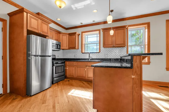 a kitchen with stainless steel appliances granite countertop a refrigerator and a sink