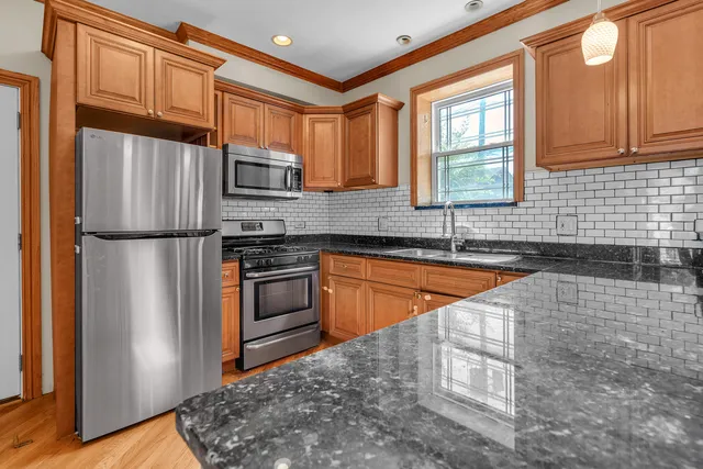 a kitchen with stainless steel appliances granite countertop a refrigerator and a sink