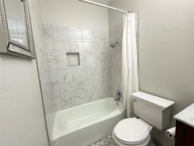 a bathroom with a sink toilet a mirror a vanity and shower
