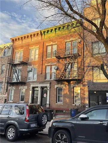 a front view of a building with lot of cars parked