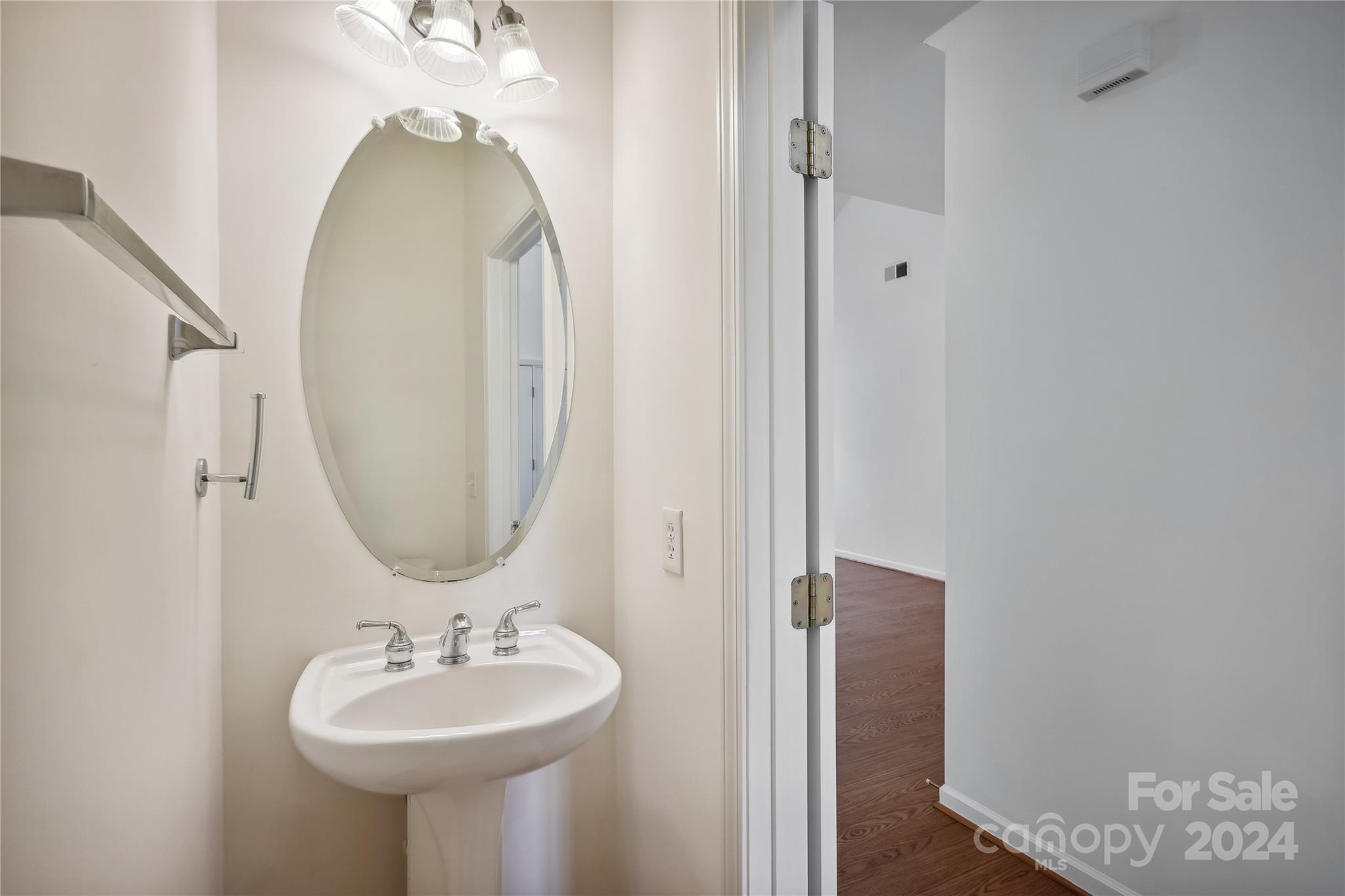 14336 Williams Glenn Road Charlotte, NC 28273 - Photo 18 of 39 a bathroom with a sink a mirror and a wooden floor