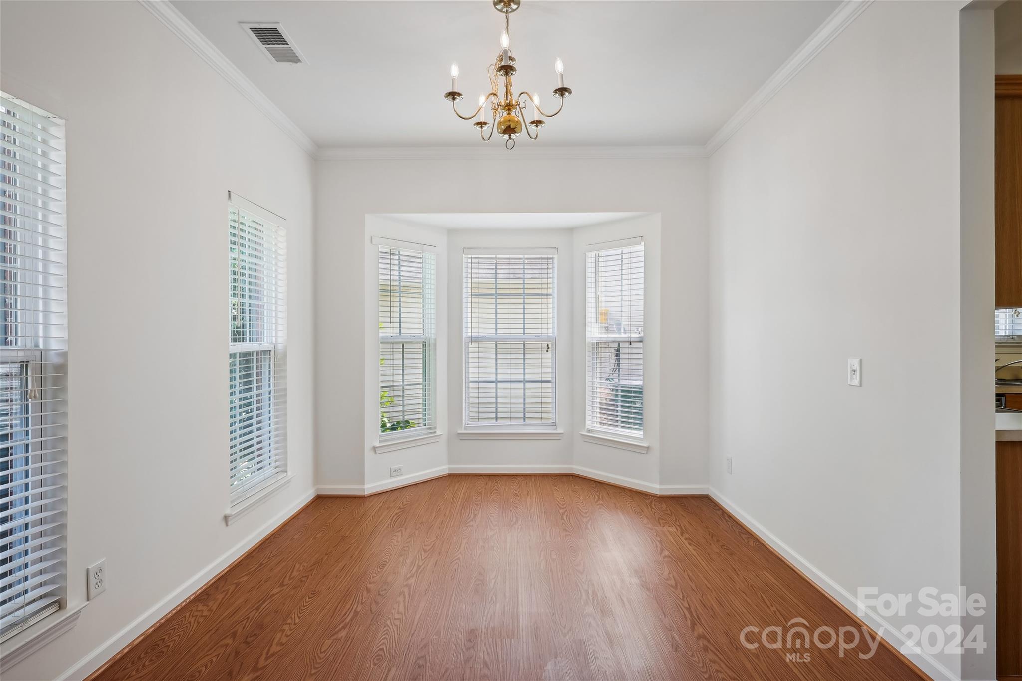 14336 Williams Glenn Road Charlotte, NC 28273 - Photo 6 of 39 an empty room with wooden floor chandelier and windows
