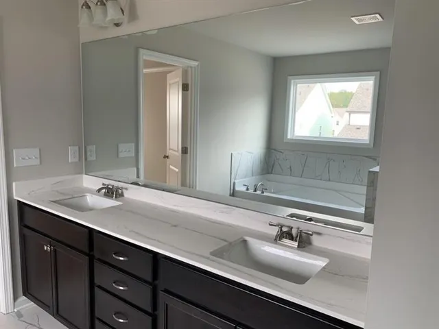 a bathroom with a sink double vanity and mirror